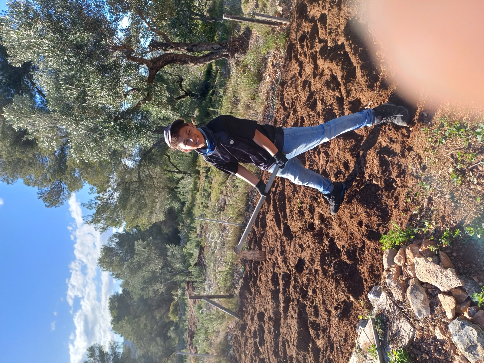 Young participant tending a community garden as part of practical learning
