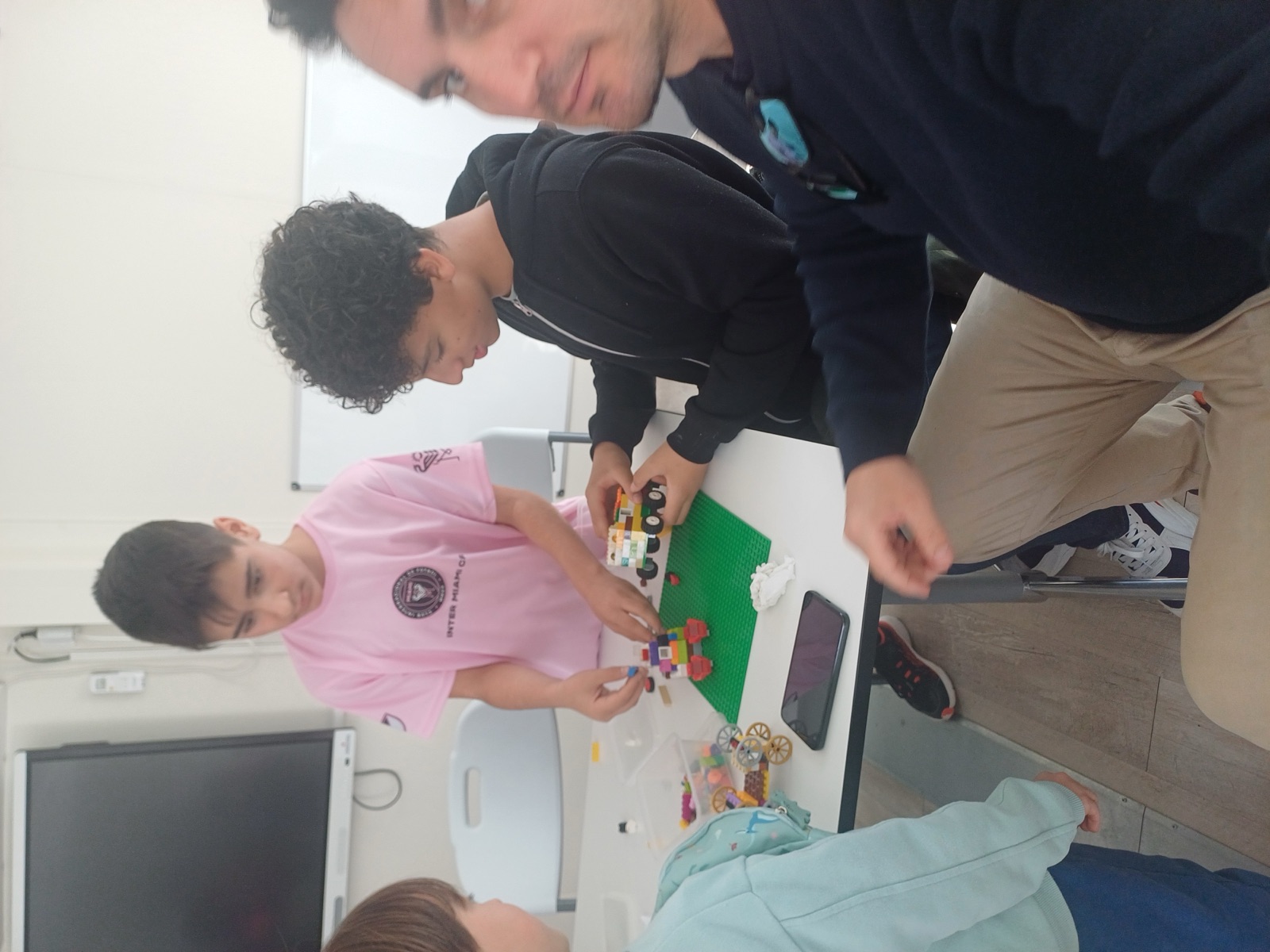 Young people and a mentor building a collaborative STEM project
